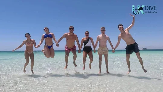 Friends jumping on a sandy island beach