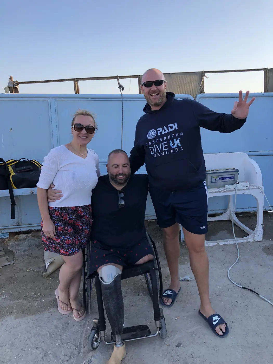 Three people together beside diving equipment in Hurghada