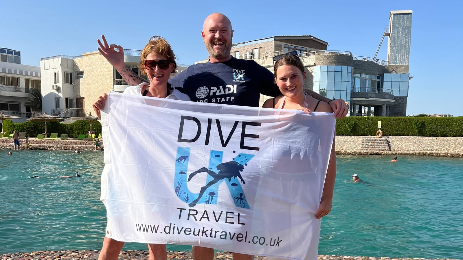 Two students with their instructor after completing the PADI Open Water course in Hurghada
