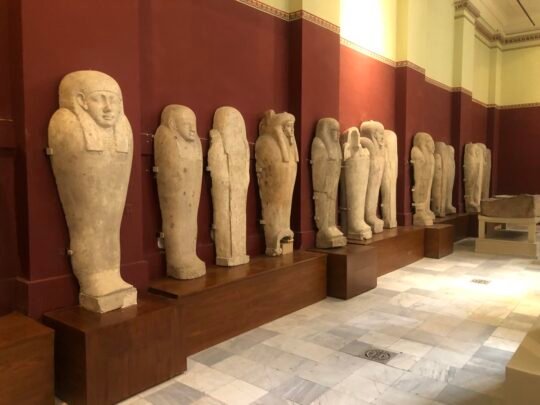 A row of ancient Egyptian stone coffins displayed in a Cairo museum