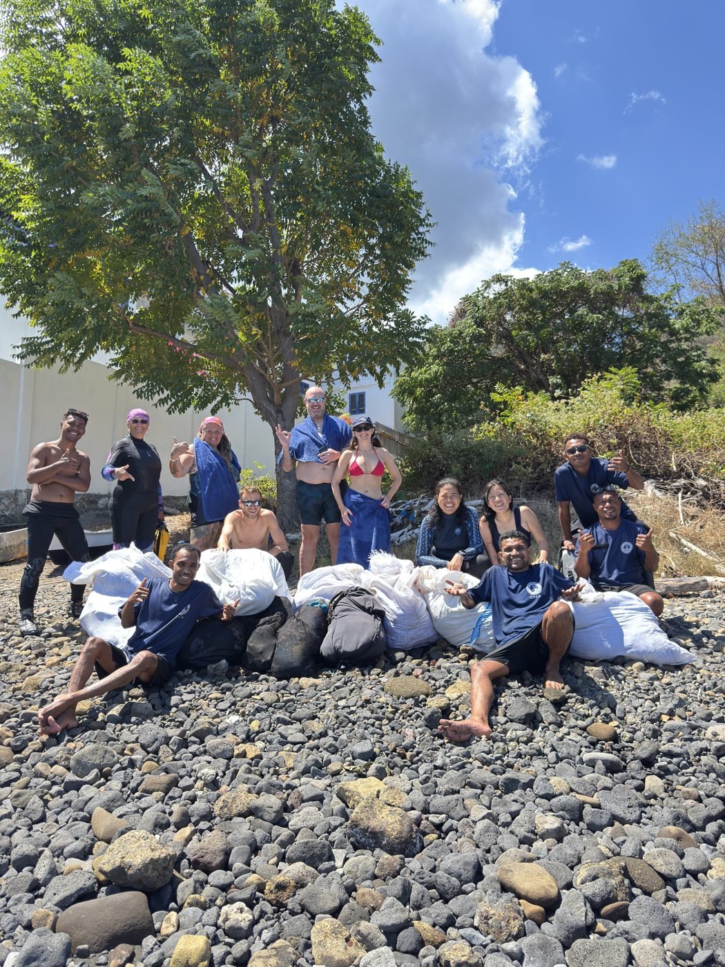Conservation team beside bags of rubbish collected underwater in Indonesia