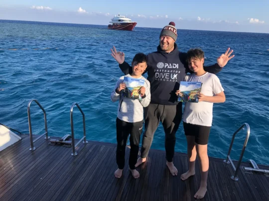 Young Open Water divers with their instructor in Hurghada, ready for the next step towards Junior Advanced