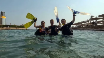 Young divers holding their fins in shallow water on the Junior PADI Advanced course page in Hurghada