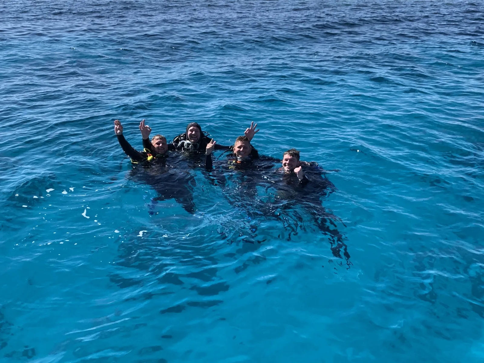 Four scuba divers at the surface in the Red Sea, Hurghada